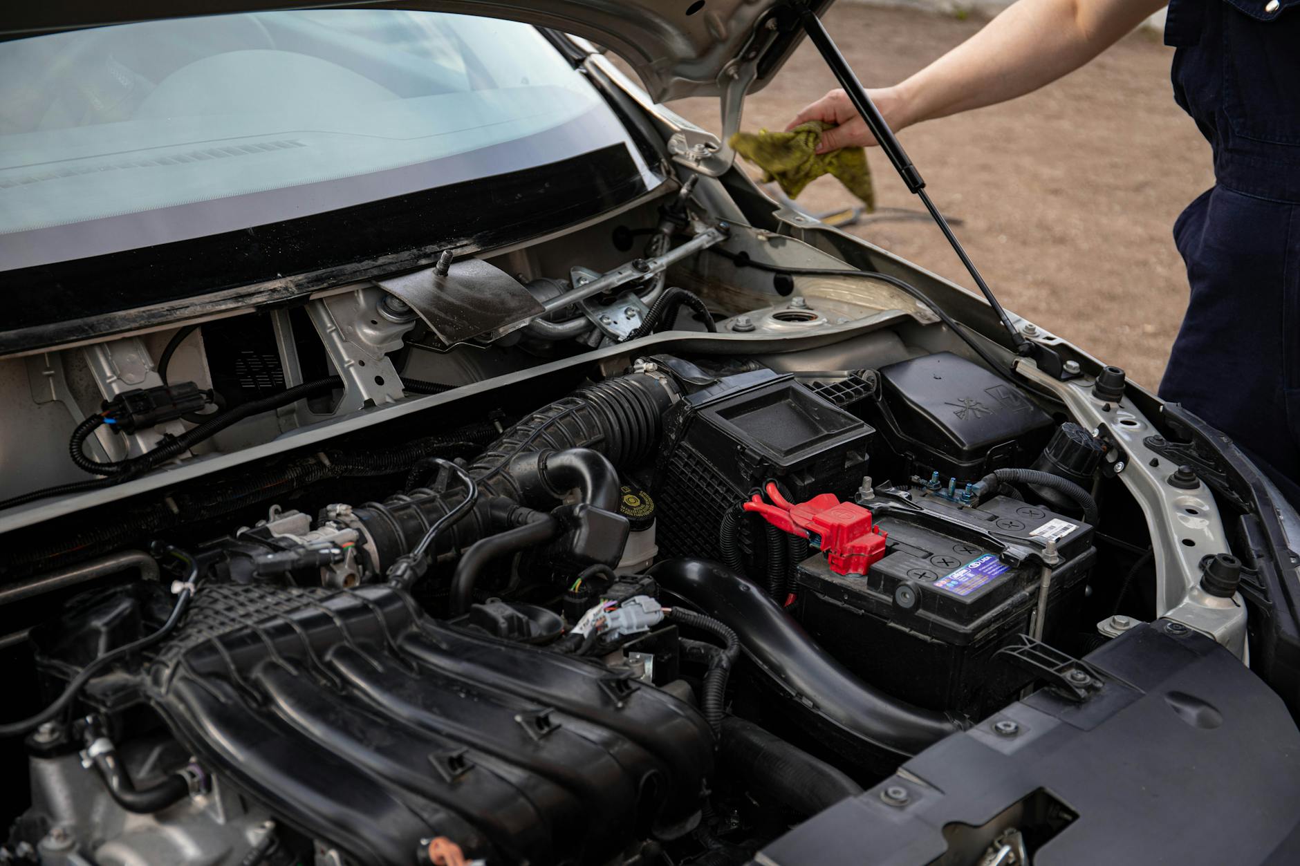 Mechanik sprawdza komorę silnika i akumulator w Suzuki Swift