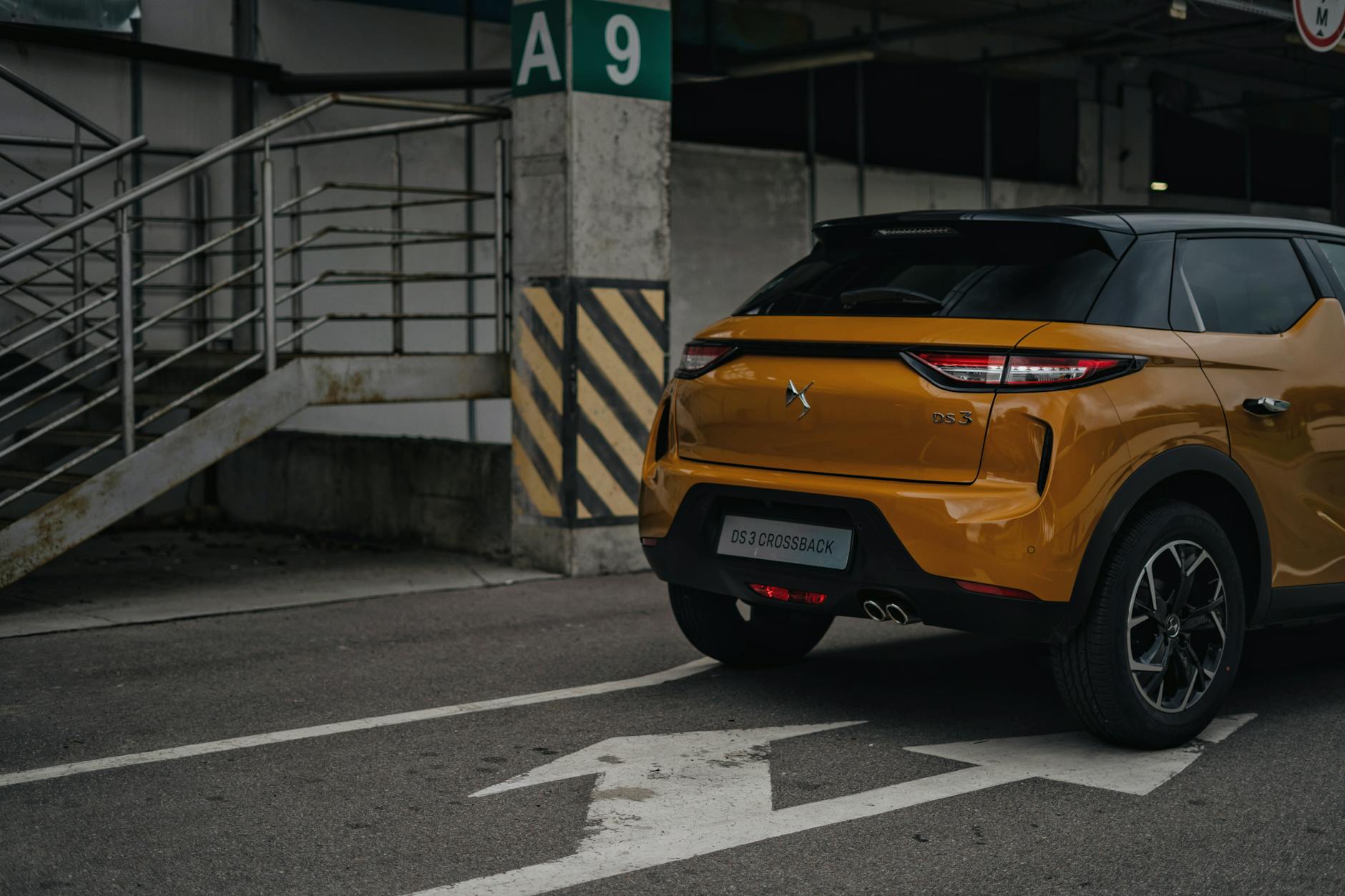 Żółty crossover DS 3 Crossback zaparkowany przy znaku drogowym w mieście