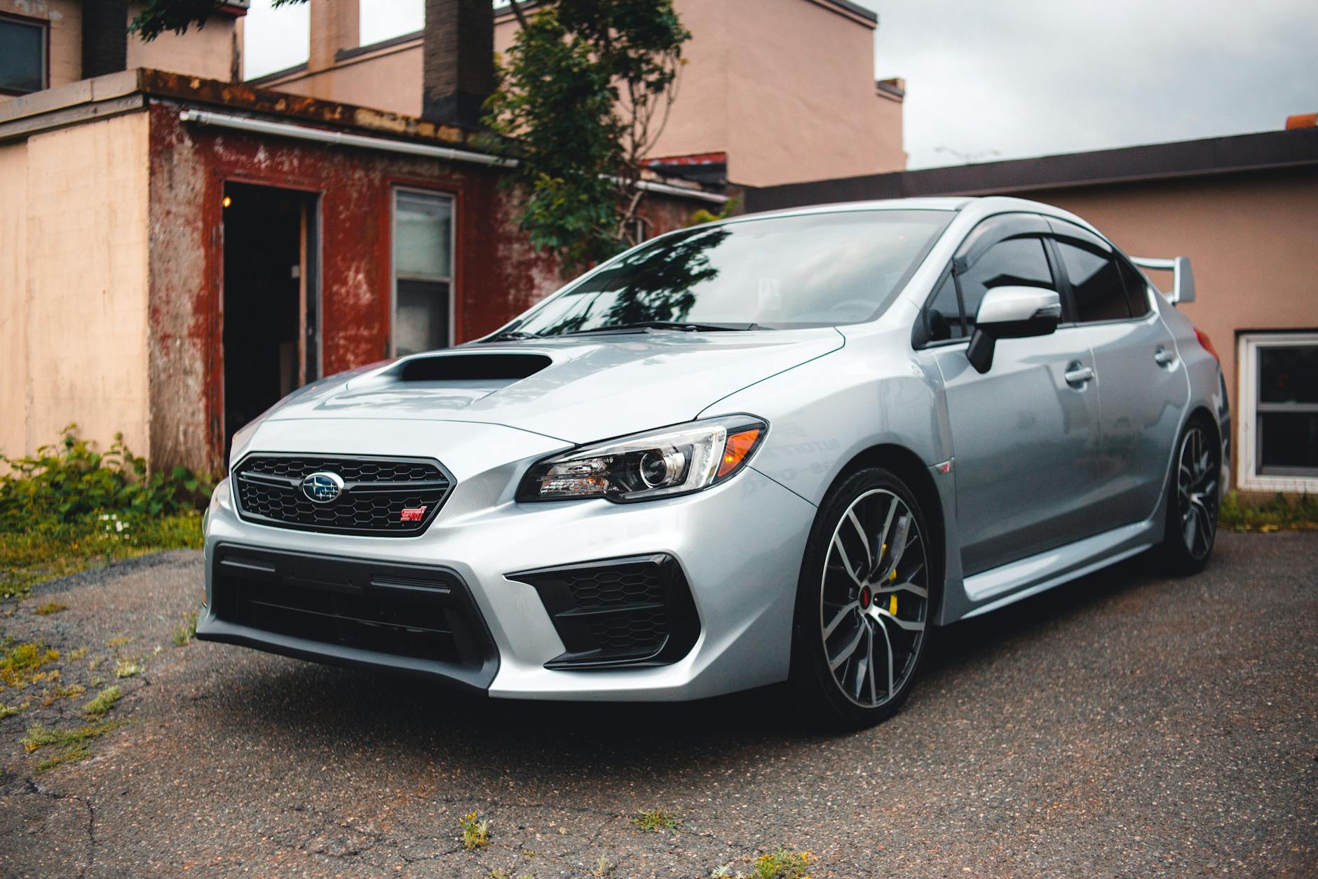 Srebrne Subaru WRX STI na podjeździe przed domem na wsi
