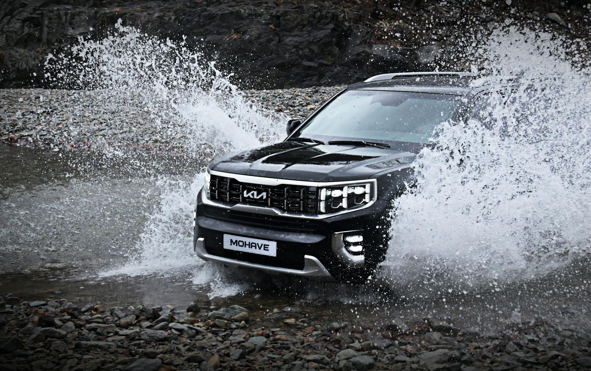 SUV Mercedes przejeżdża przez kamienisty, zalany wodą teren