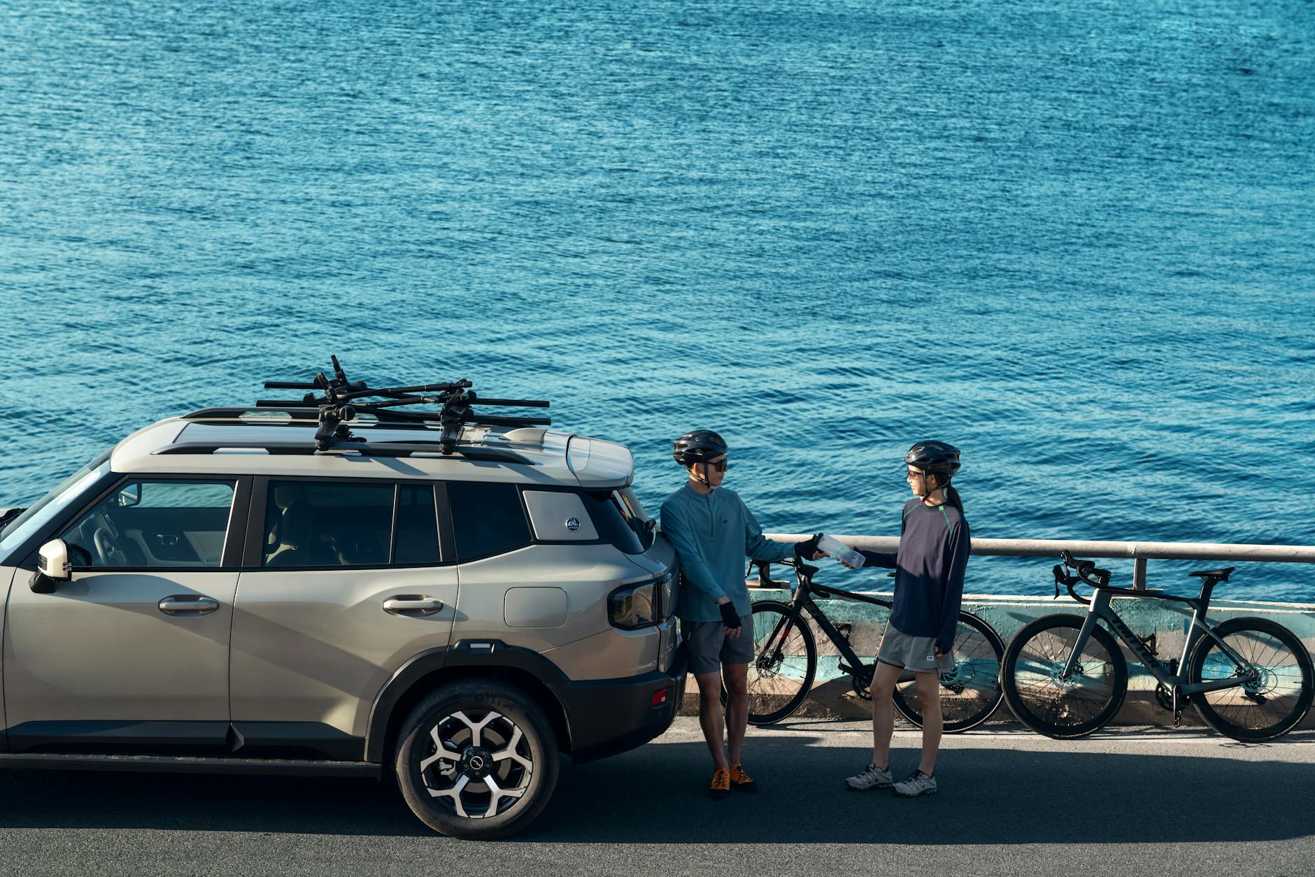 SUV nad oceanem zaparkowany obok rowerzystów przygotowujących się do jazdy