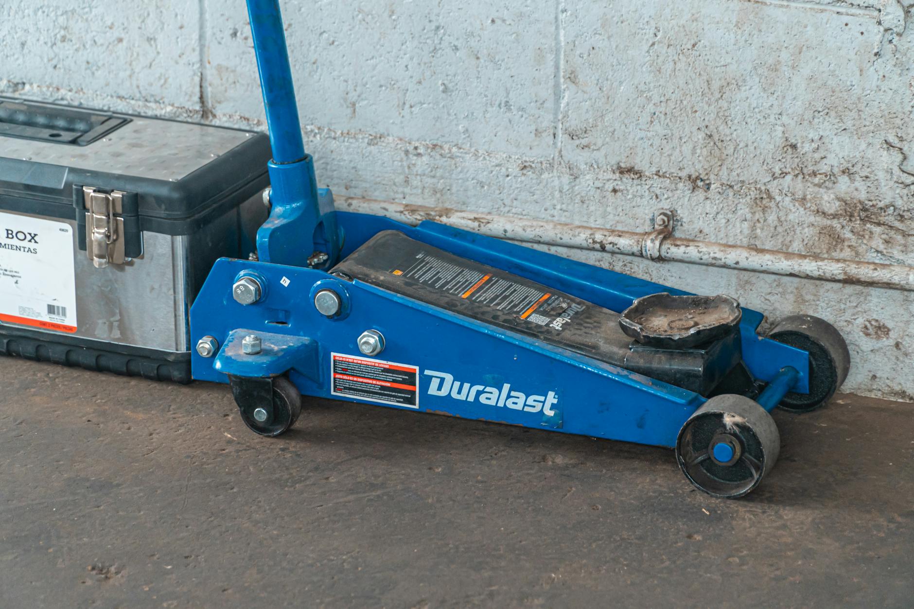 Niebieski podnośnik hydrauliczny i skrzynka narzędziowa w garażu samochodowym