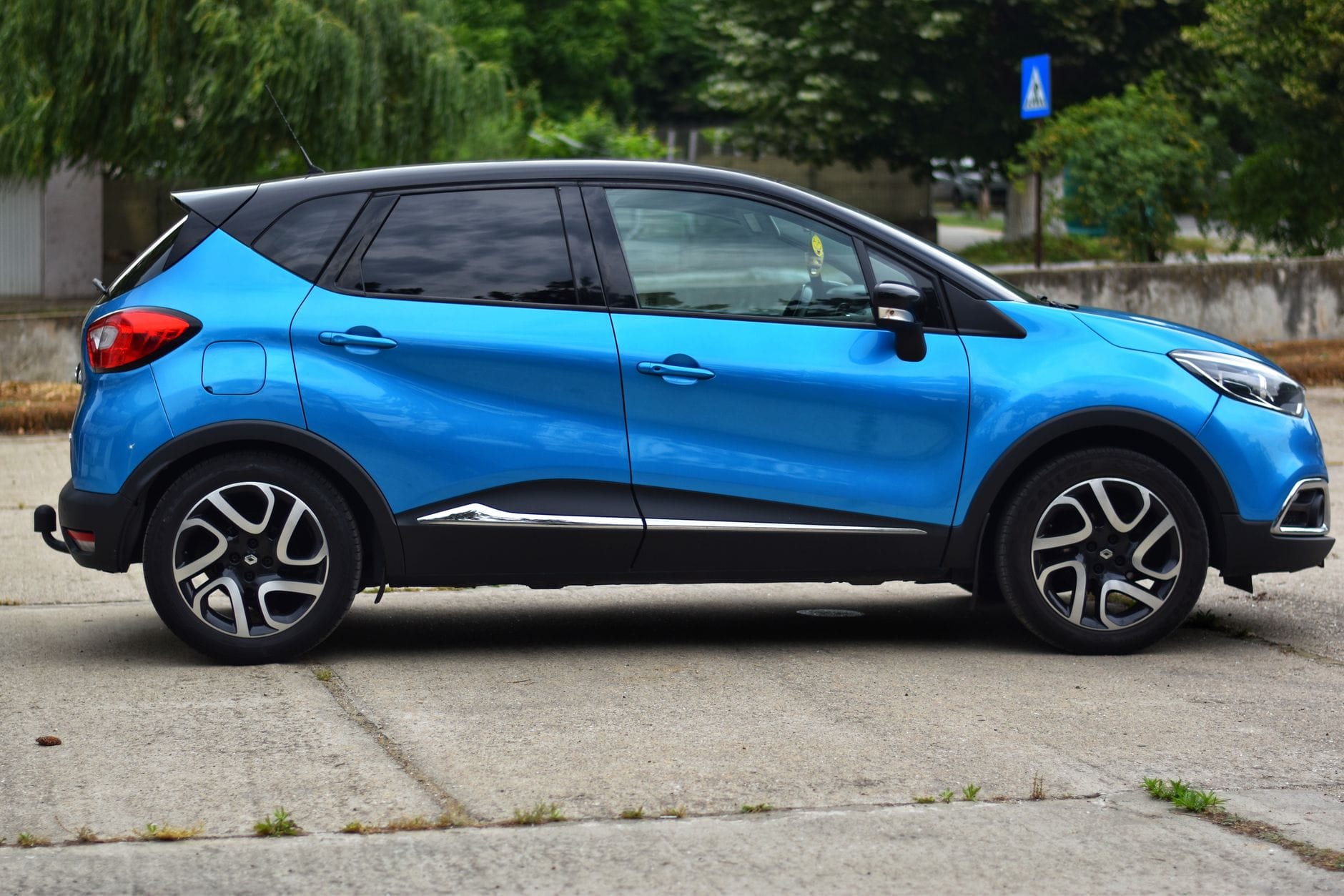Niebieski kompaktowy SUV Nissan zaparkowany na betonowym placu