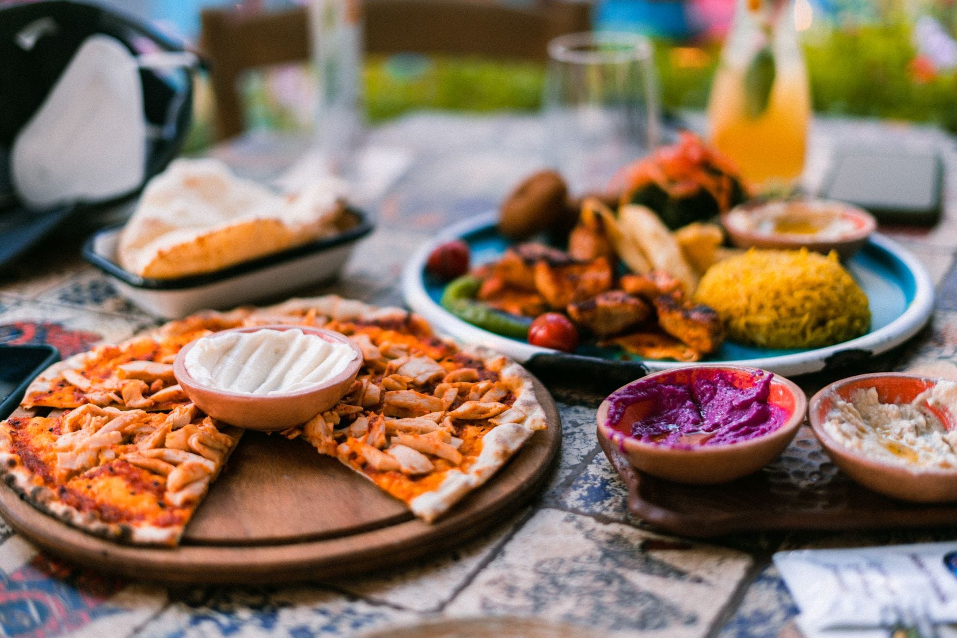 Pizza na śródziemnomorskim stole z kolorowymi dipami i dodatkami