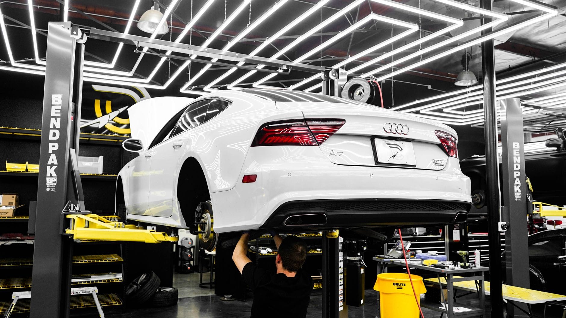 Mechanik serwisuje biały luksusowy Rolls-Royce w nowoczesnym warsztacie
