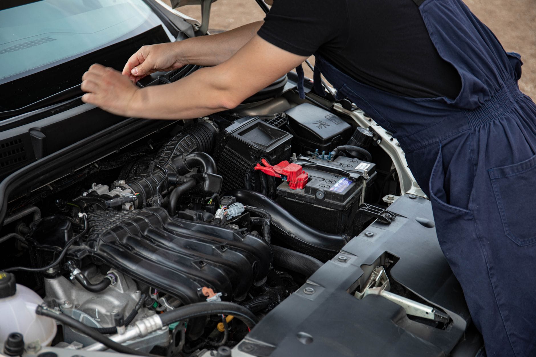 Mechanik serwisuje silnik samochodu podczas przeglądu na zewnątrz